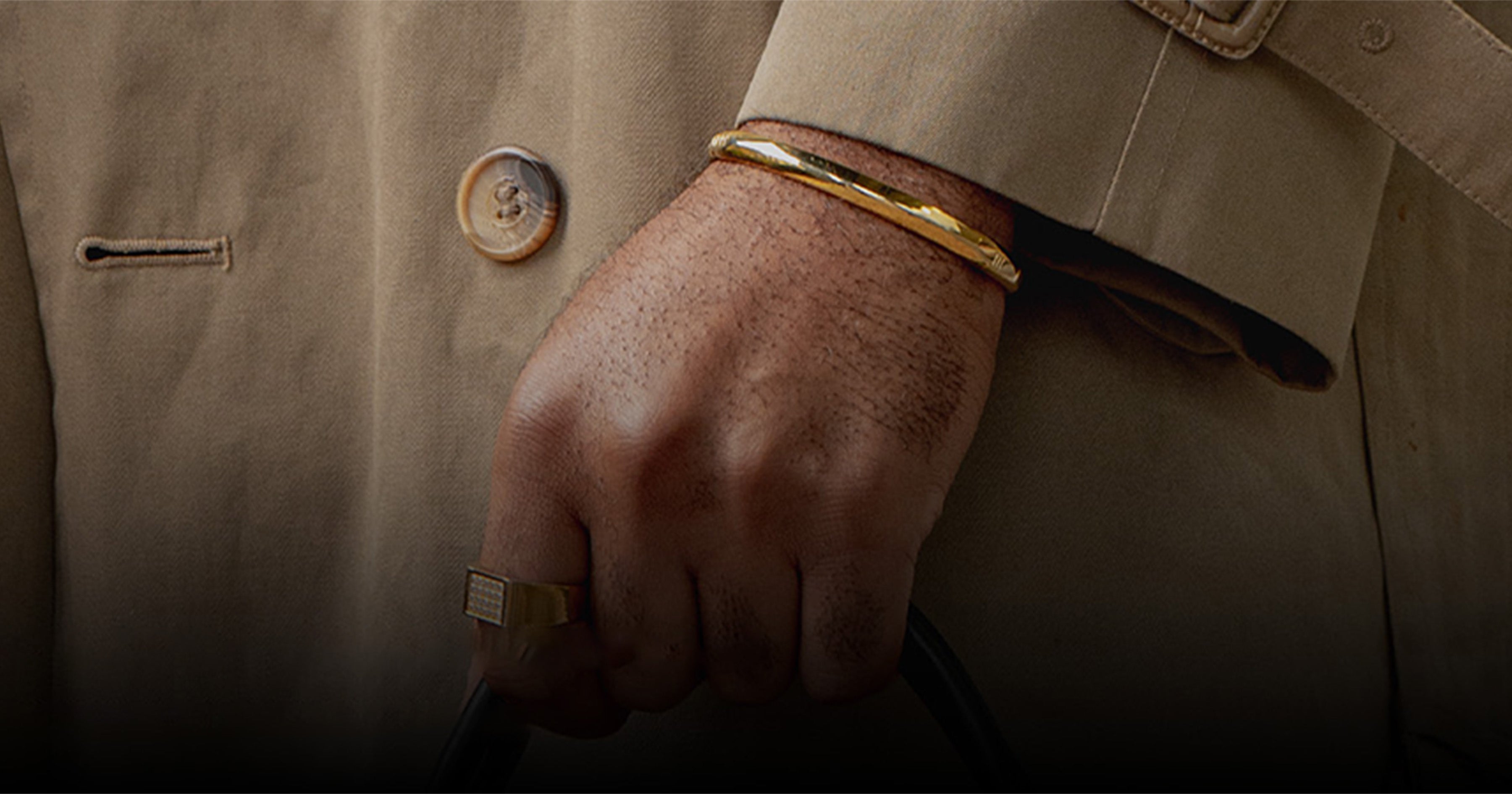 Man's hand wearing 3 Kings Legacy gold bracelet and ring, symbolizing luxury, style, and Black excellence.
